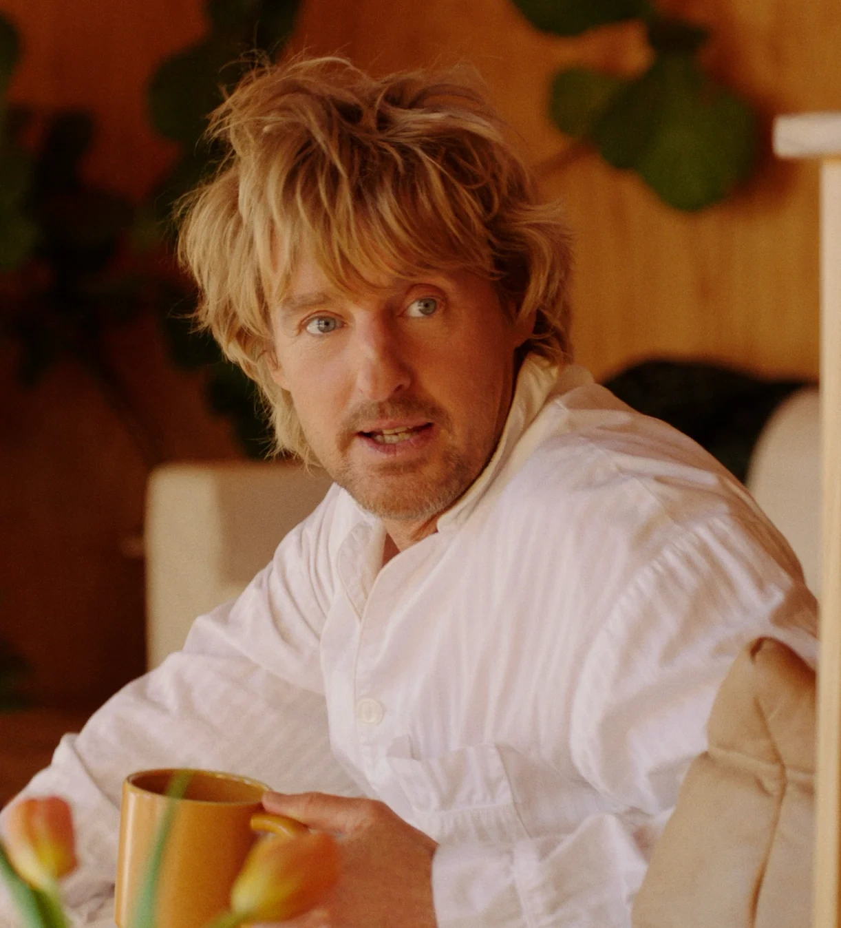 Owen Wilson in a white shirt, holding two mugs