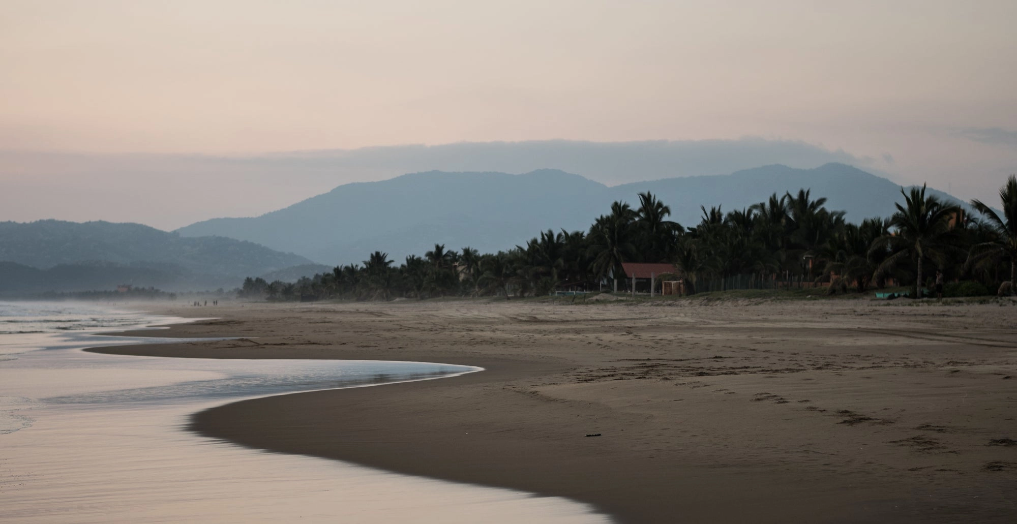 Low tide on a quiet beach with hazy mountains